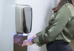 Woman using hand dryer Woman using hand dryer