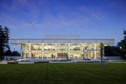 Evening view of a two story academic building light up from within shining out through full glass windows