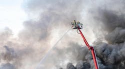 Fireman fighting fire with water hose