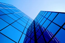 Office building windows. Office building details reflecting blue sky and clouds in windows