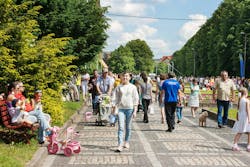 A lot of people walking in a city park on a day off