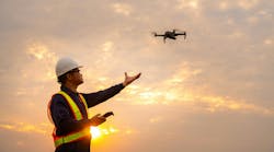 Surveyor deploying drone to view construction sites or check security at sunset.